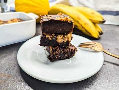Brownies z arašídového másla na bílém dezertním talířků s vidličkou