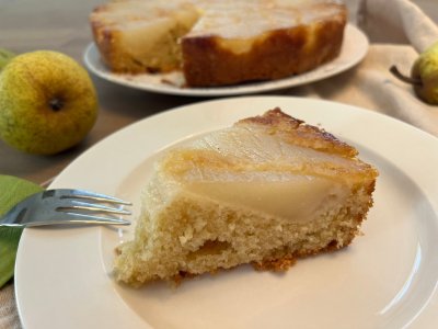 Kousek obráceného hruškového koláče servírovaný na bílém talíři