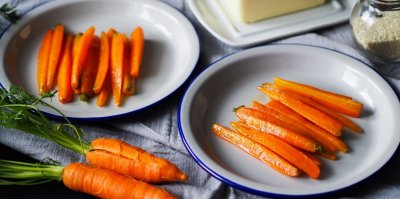 Dušená mrkev servírovaná na bílých talířích