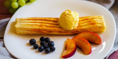 Vafle s ovocem a zmrzlinou na bílém talíři