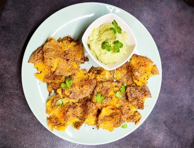 Upečené brambory s avokádovým dipem na bílém talíři