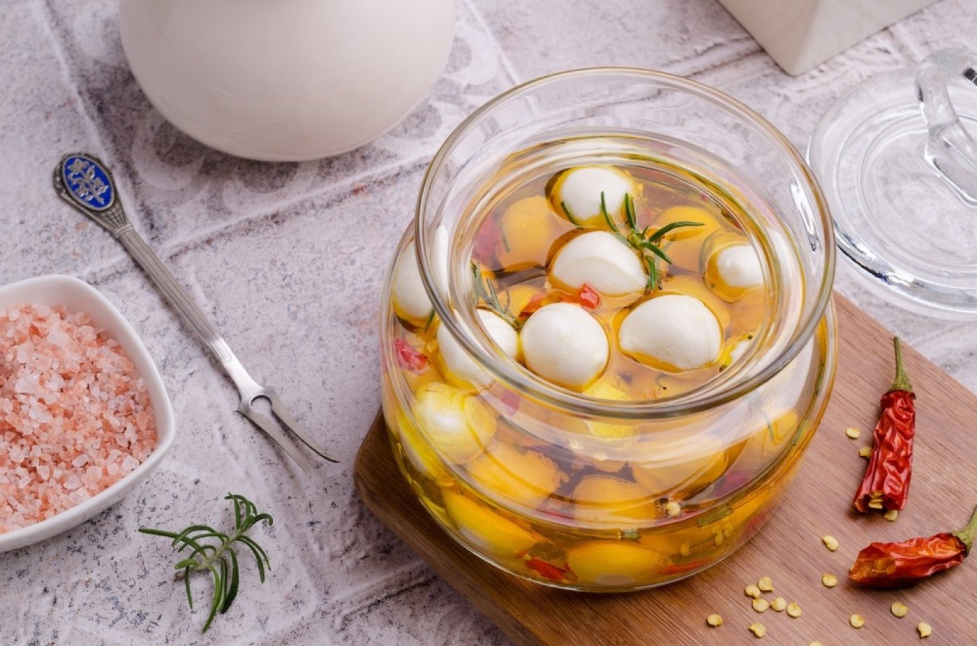 Nakládaná mozzarella v oleji  s kořením ve sklenici na dřevěném prkénku