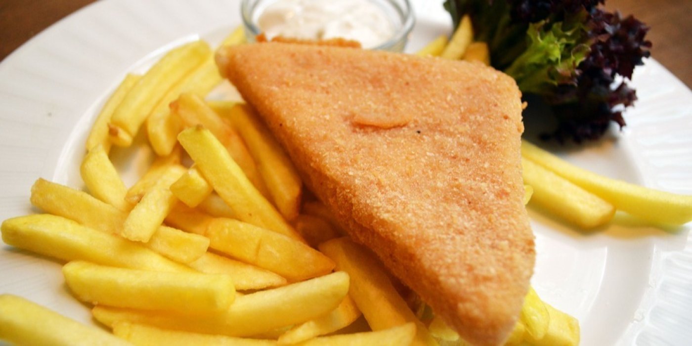 Smažený sýr na hranolkách na bílém talířku