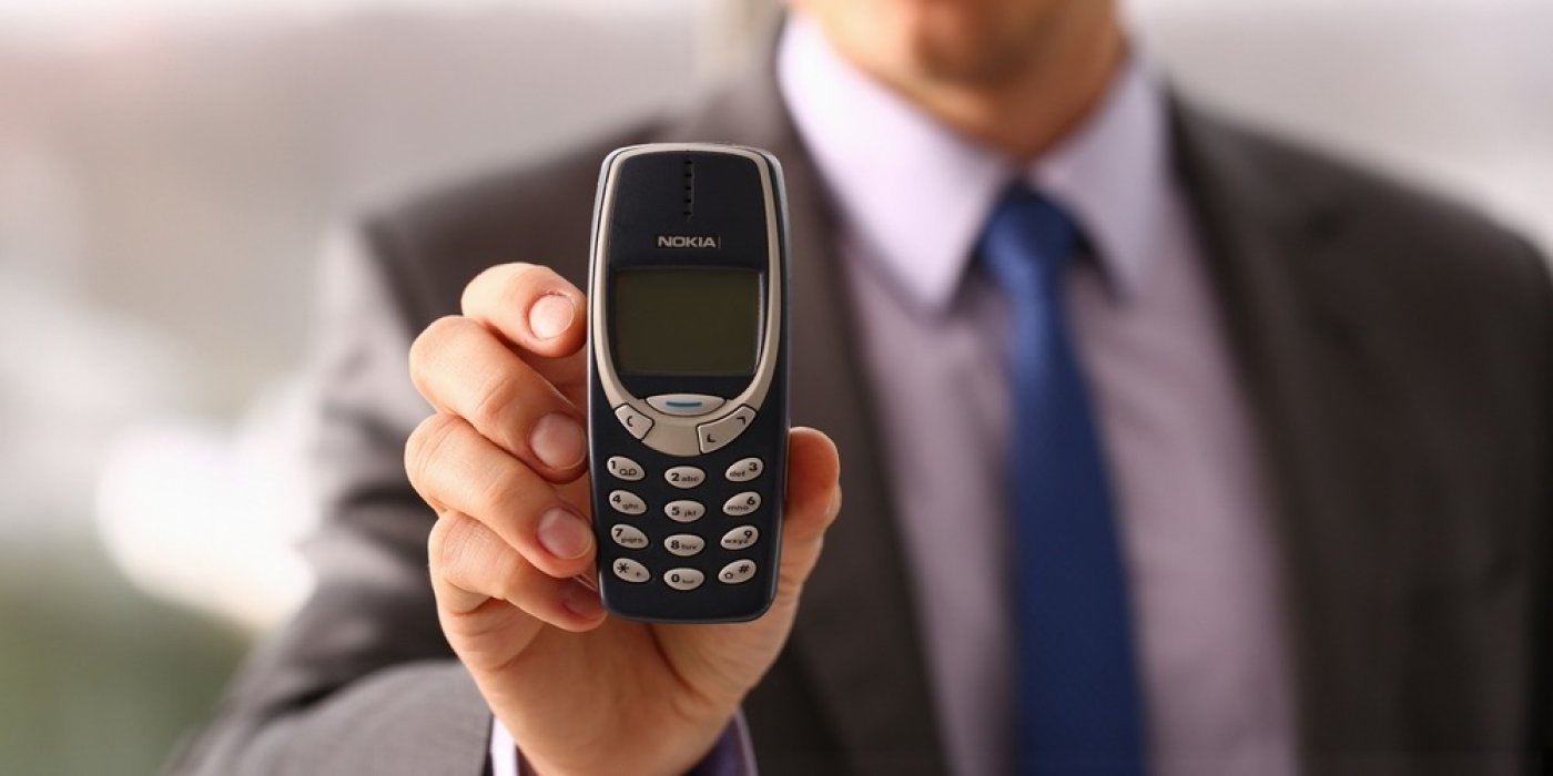 Muž drží Nokiu 3310