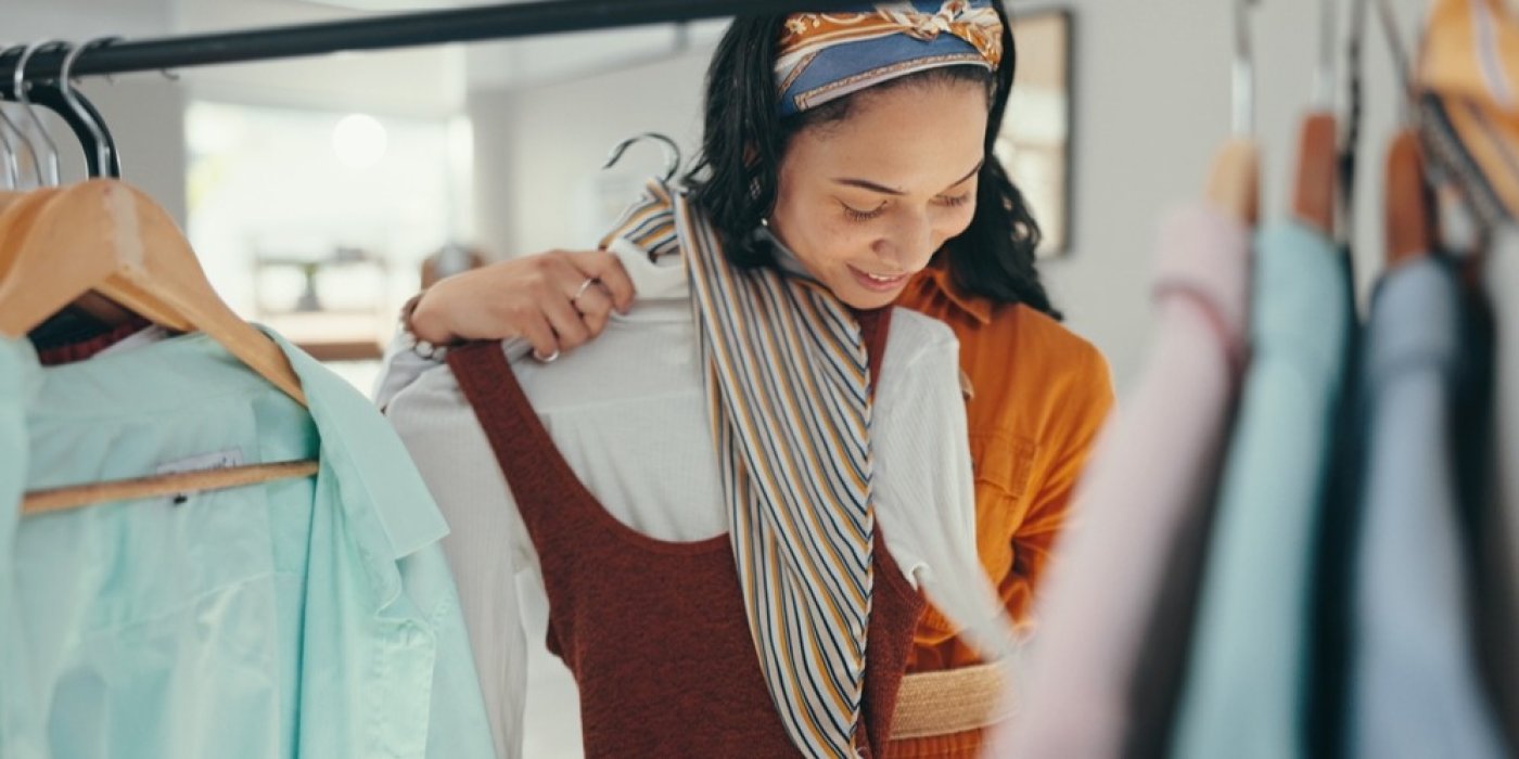 Žena si přikládá oblečení na sebe