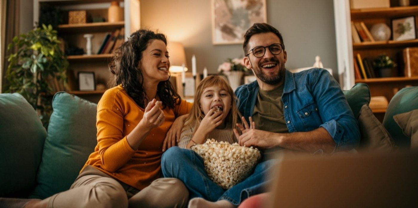 Mladá rodina s mísou popcornu se dívá na film