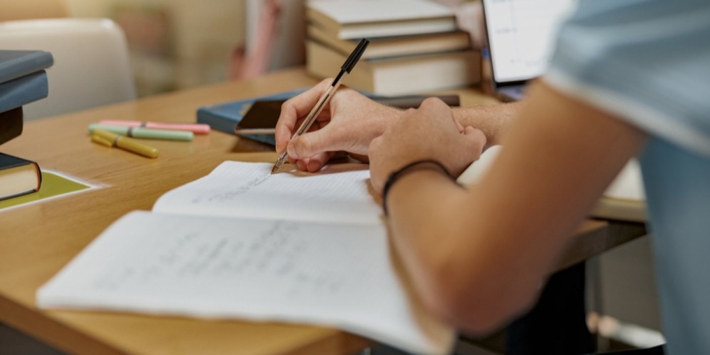 Dítě píše do sešitu na psacím stole