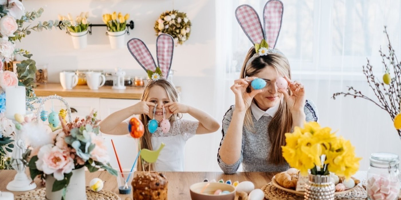 Žena s mladou dívkou barví velikonoční vajíčka