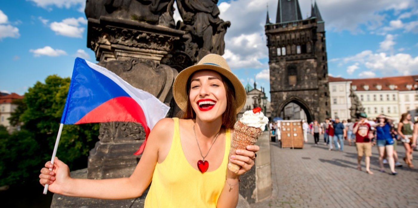 Žena drží českou vlajku v ruce na Karlově mostě