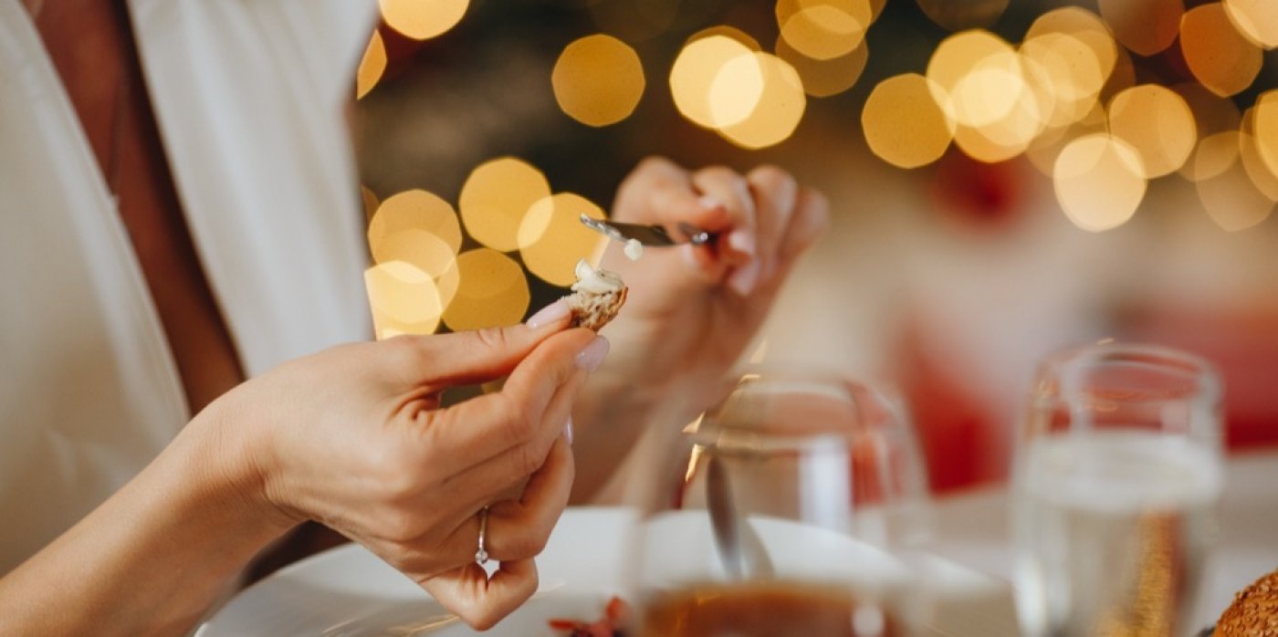 Žena si natírá na kousek chleba máslo