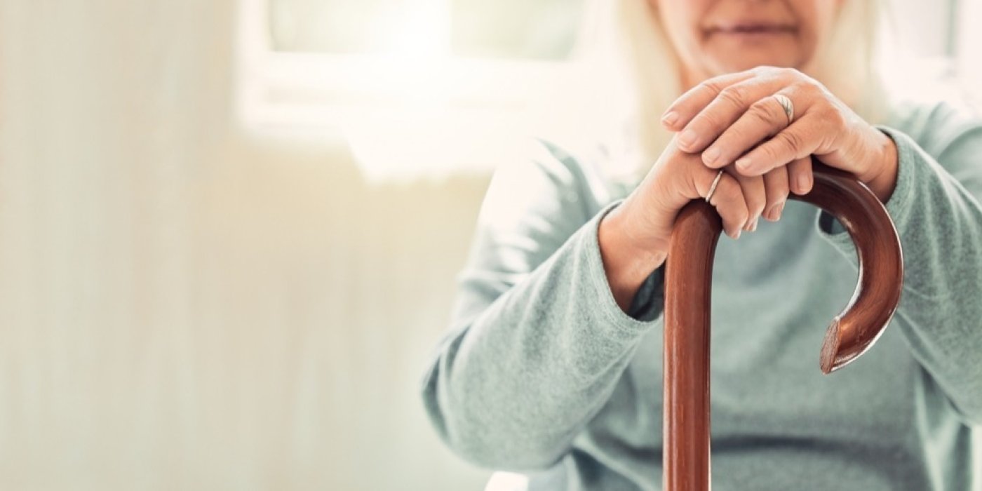 Starší žena drží hůl