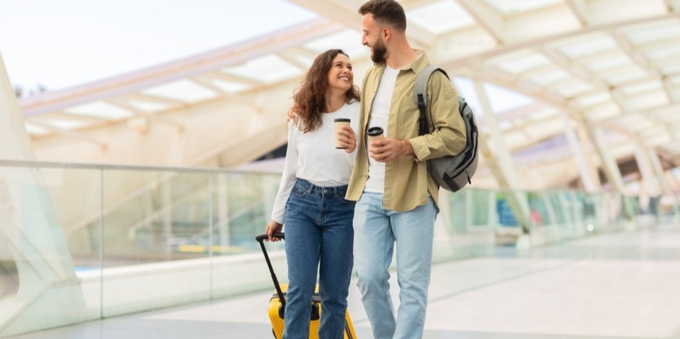 Pár na letišti s batohem a kufrem