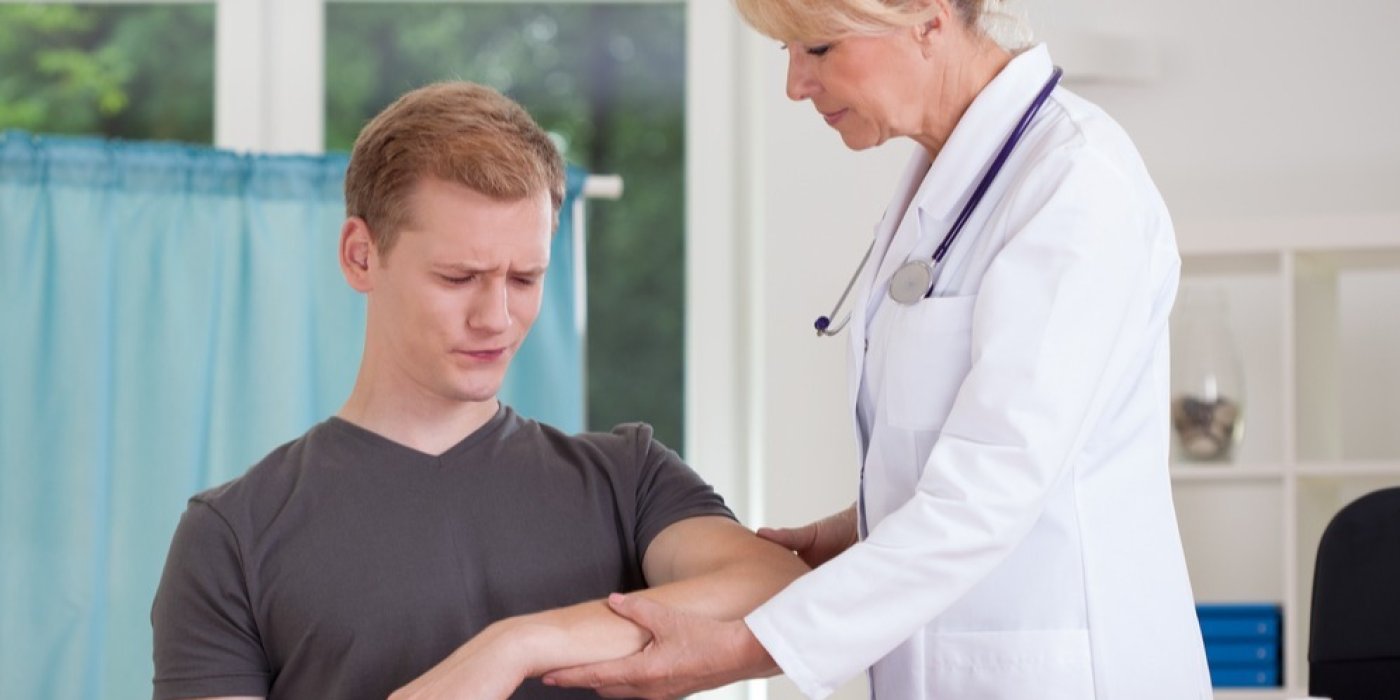 Lékařka ošetřuje mladého muže v ordinaci