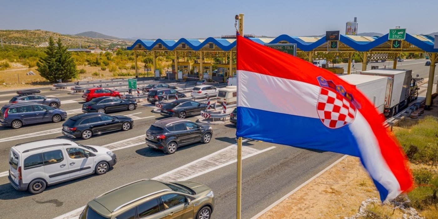 Auta na silnici, v popředí vlajky Chorvatska