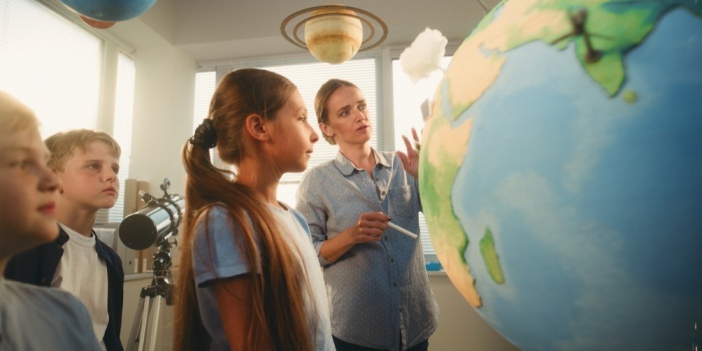 Učitelka děti učí o zemi