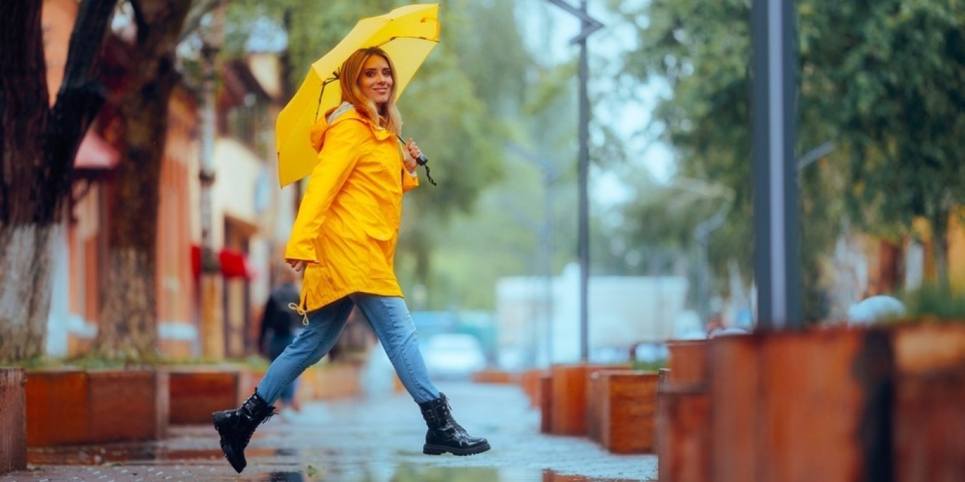 Žena s deštníkem přechází cestu