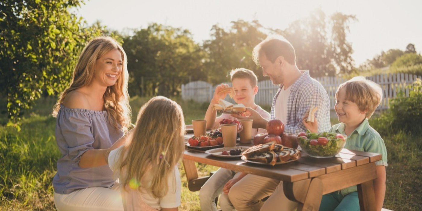 Rodina jí na zahradě u stolu