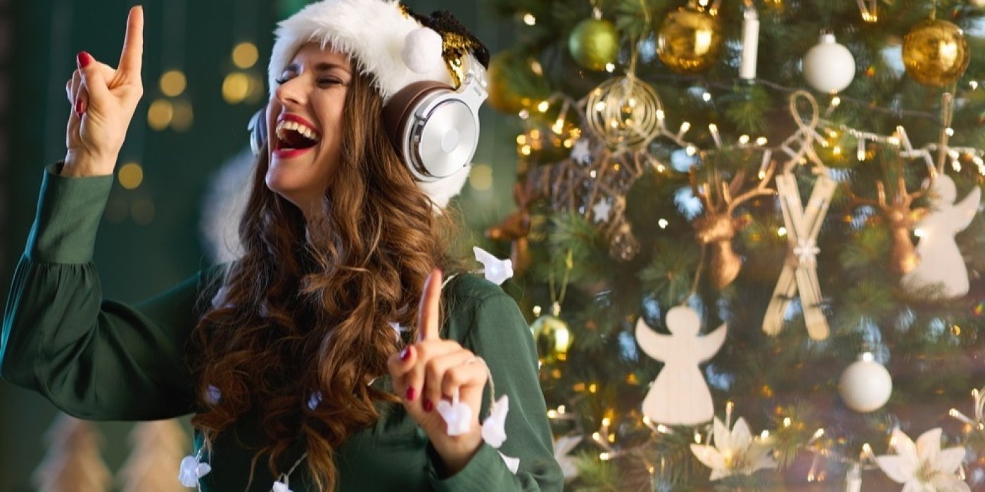 Žena se sluchátky poslouchá vánoční písně