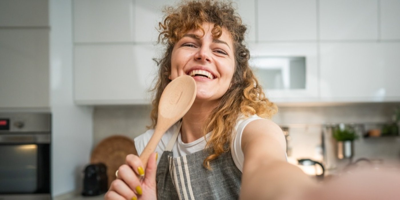 Žena zpívá do vařečky